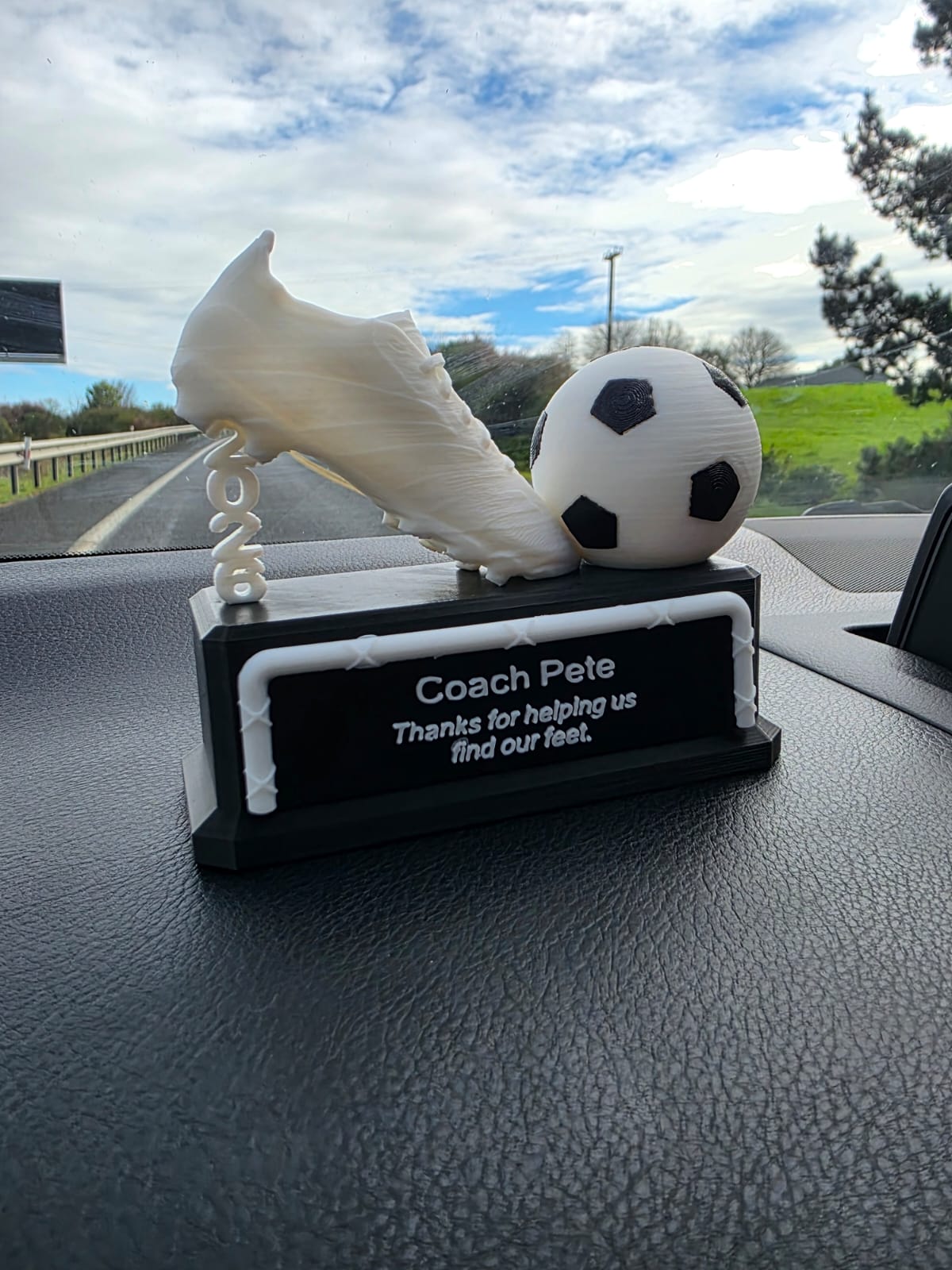 Rugby coach trophy close-up showing boot and Gilbert ball detail